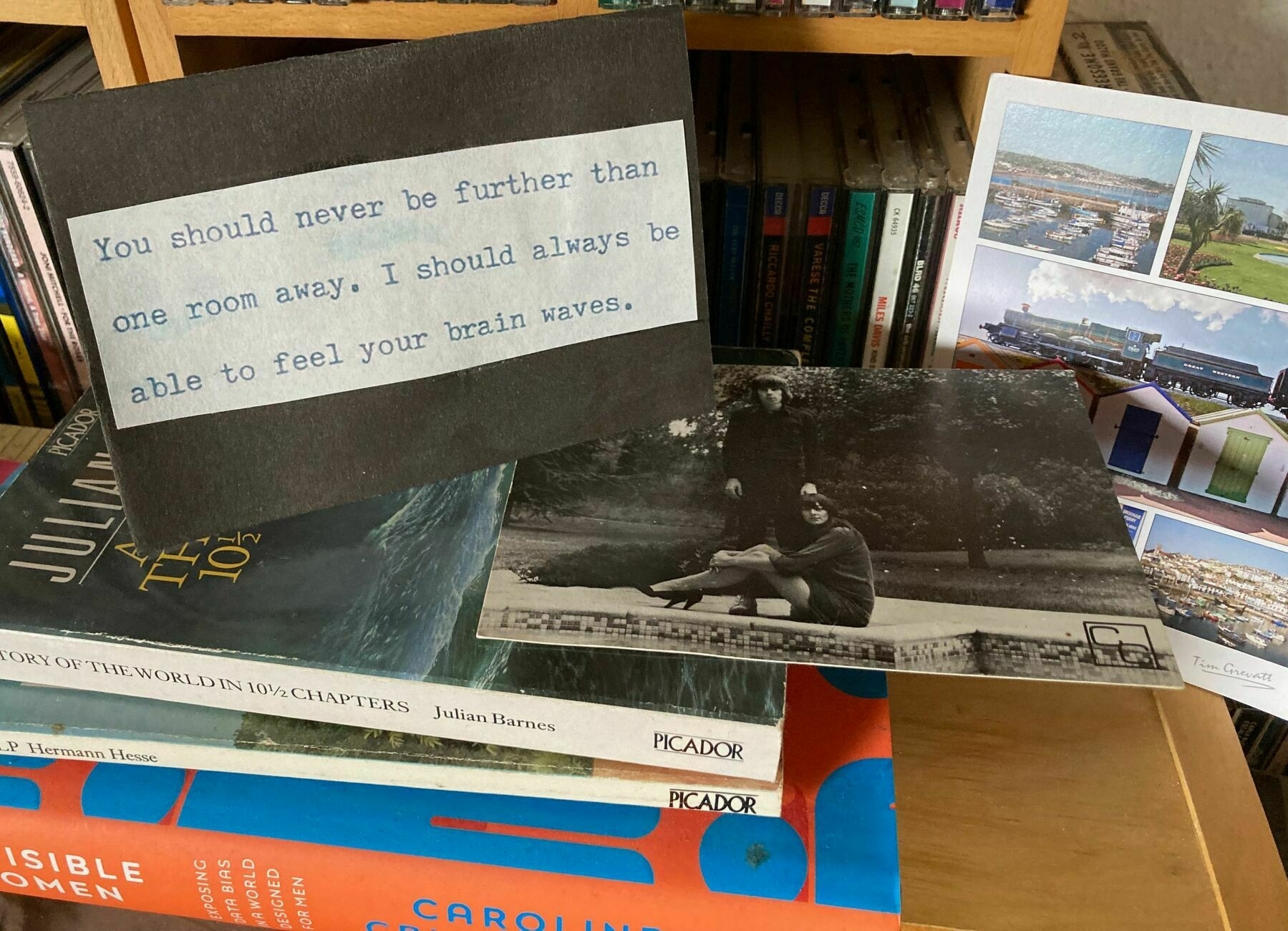 Three cards displayed on a dusty bookcase.  