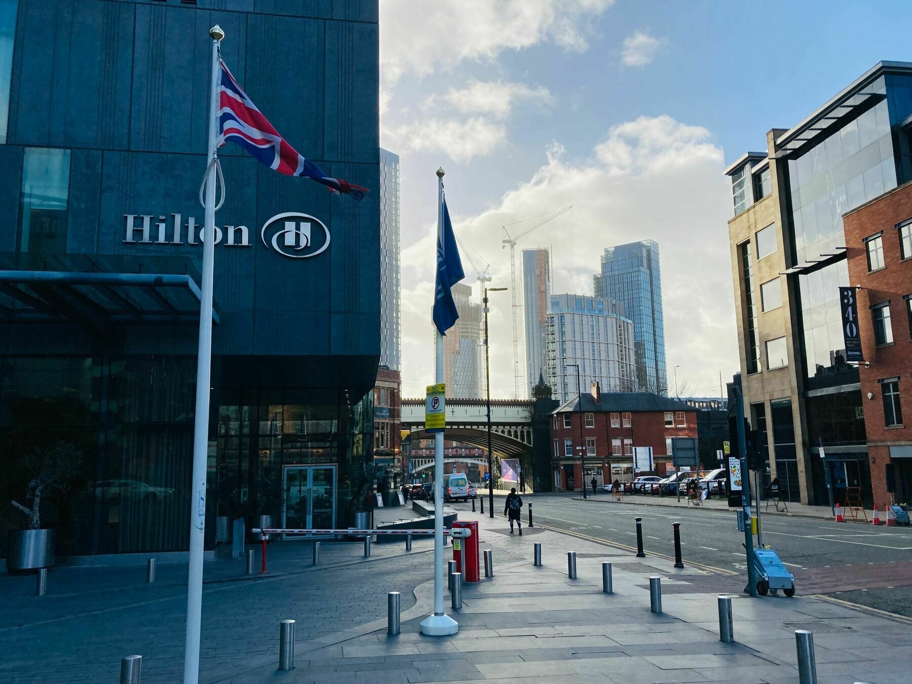 A view along Deansgate in Manchester; beyond a railway bridge tower blocks are being constructed.